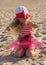 Blond girl in lifebuoy ring on the sand