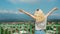 blond girl with outstretched hands on a marvelous view of Alazani valley and Caucasus mountains in Georgia. full shot