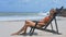 Blond Girl Relaxes in Beach Wooden Chaise Longue