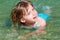 Blond girl swimming in lake river