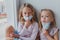 Blond girls do not want to get sick do not want to wear masks against coronovirus. children want to go outside covid