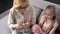 Blond grandmother knitting with her little granddaughter at home, handmade