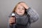 Blond hair little girl holding cough syrup in a hand. Sick child.. Child winter flu health care concept