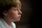 A blond hair teen boy with blue eyes looks contemplative.