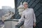 Blond hair woman standing on the balcony nice view on the old city town morning meeting wear beige suit glasses businesswoman