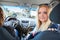 Blond hair young woman a passenger looking back when driving car