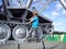 A blond-haired boy in a blue T-shirt climbed onto a metal structure. An old tractor with caterpillar wheels turned into a mosquito