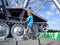 A blond-haired boy in a blue T-shirt climbed onto a metal structure. An old tractor with caterpillar wheels turned into a mosquito