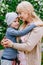 Blond happy young grandma hugging child of five years