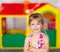 Blond kid girl crossed arms in toy house