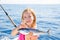 Blond kid girl fishing tuna little tunny happy with catch