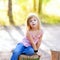 Blond kid girl in tree trunk forest