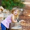 Blond kid girl in tree trunk forest