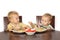 Blond little boy trying to eat with a fork potatoes with meat and tomatoes