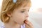 Blond little girl closeup portrait eating biscuit