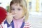 Blond little girl portrait eating with spoon