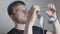 A blond man with a beard, a photographer, examines a film, on a white background