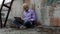 Blond man sits on a construction site and works at his laptop