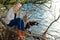 Blond melancholic woman sitting by a lake