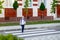 A blond schoolboy with glasses and a backpack goes to school on a pedestrian crosswalk. Day of knowledge