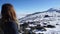 Blond strong mountaineer lady, alone observing with inspiration the challenge summit with snow.