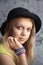 Blond teenage girl in black hat and rubber loom bracelets