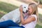 Blond teenager with old senior labrador dog in the park