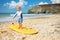 Blond toddler boy already practicing on surfboard