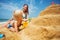 Blond toddler build a sand castle with mother