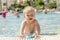 Blond toddler playing with swimming goggle in the pool