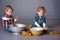 Blond toddlers playing with cooking utensils