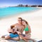 Blond tourist couple playing guitar at beach