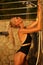 blond woman in bikini taking shower on sunset beach