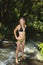 Blond woman in bikini by waterfall