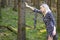 Blond woman in blue designer dress posing in woodland