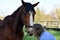 Blond woman cuddles with  her  horse