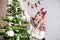 Blond woman with devils horns making christmas decoration on Christmas tree
