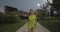Blond woman in fitness wear running training on park walkway.Front following view.Summer evening or night.Industrial