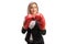 Blond woman in formal clothes wearing red boxing gloves and standing in guard position