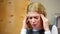 Blond woman having headache, nervous breakdown at work. Stress and problems