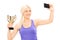 Blond woman holding a trophy and taking selfie