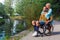 Blond woman hugging man in wheelchair outdoors by river