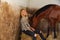 Blond woman on an indoor stable with horse