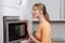 Blond woman with a microwave