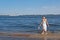 Blond woman paddling her bare feet during a flood in the background of the Volga River with a boat