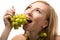 Blond woman posing with green ripe grape and kiwi