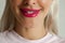 Blond woman with red lips smiling, natural teeth