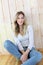 Blond woman sitting on wooden floor