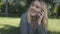 Blond woman speaking phone closeup. Attractive girl plus size lay, smile on grass. Nature landscape