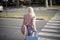 Blond woman with suitcase crosses the road